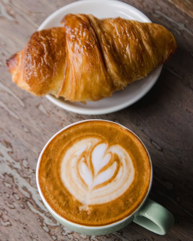 Latte art and croissant at Hama Coffee