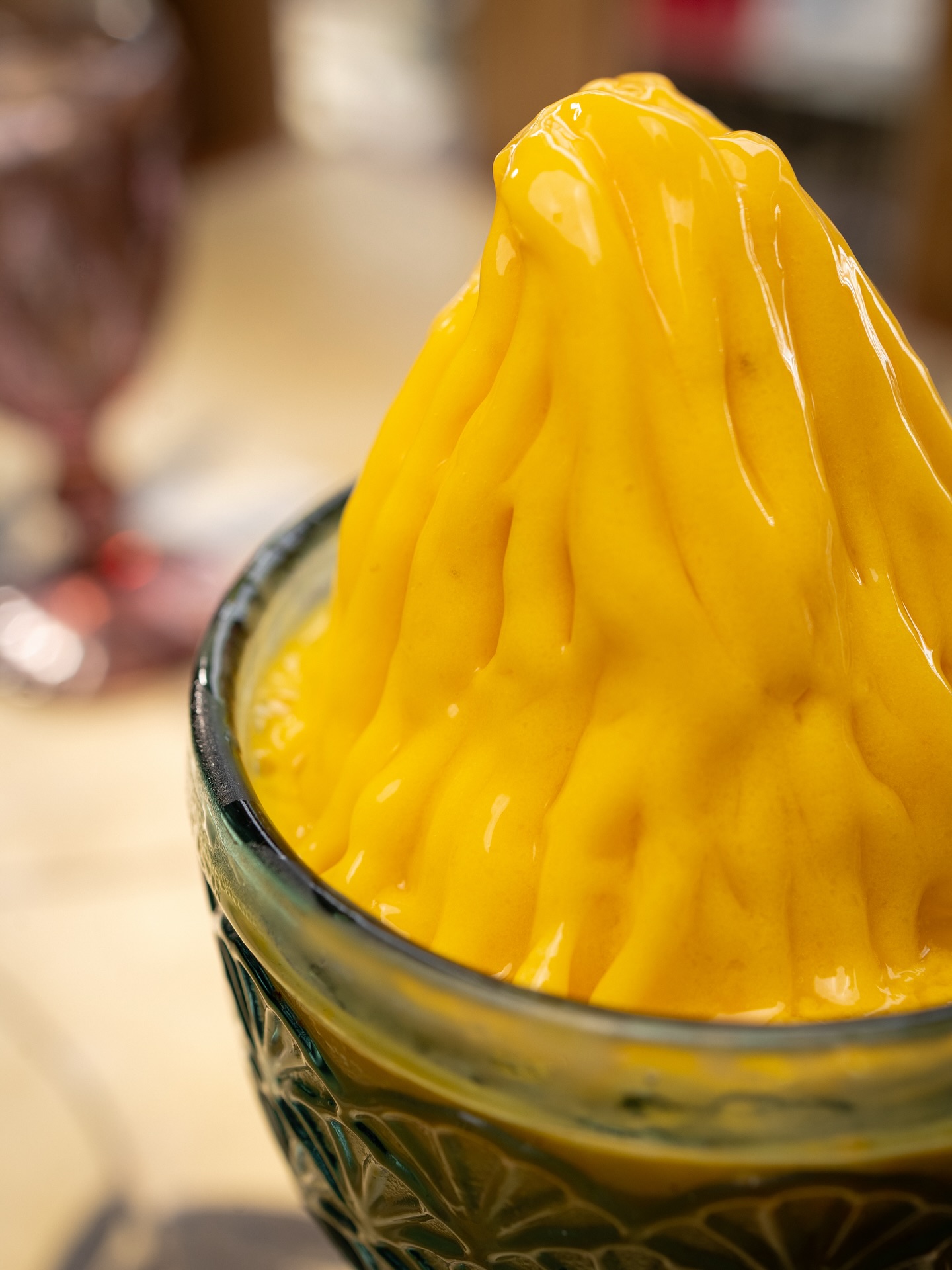 Mango soft-serve in a teal glass bowl