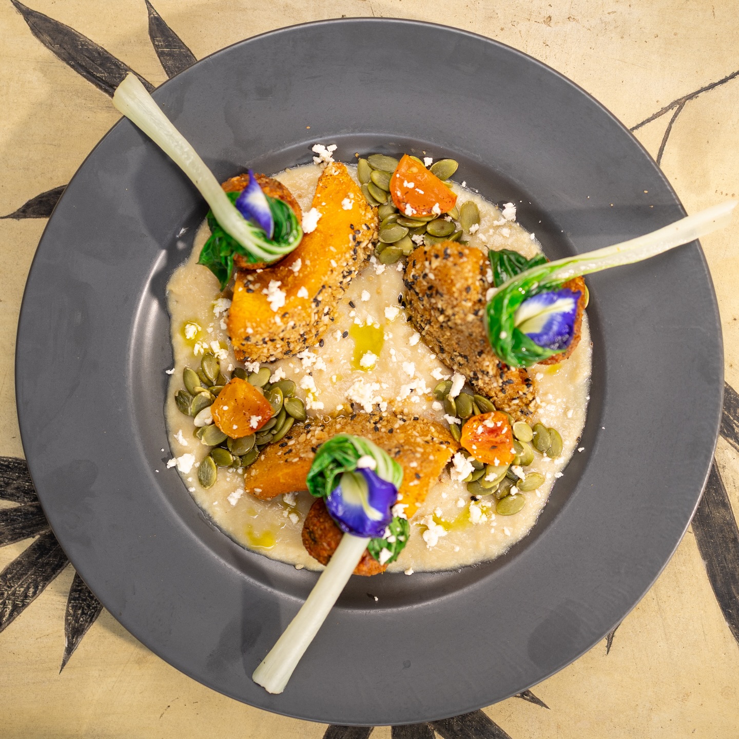 Artistic grain bowl with roasted squash and edible flowers