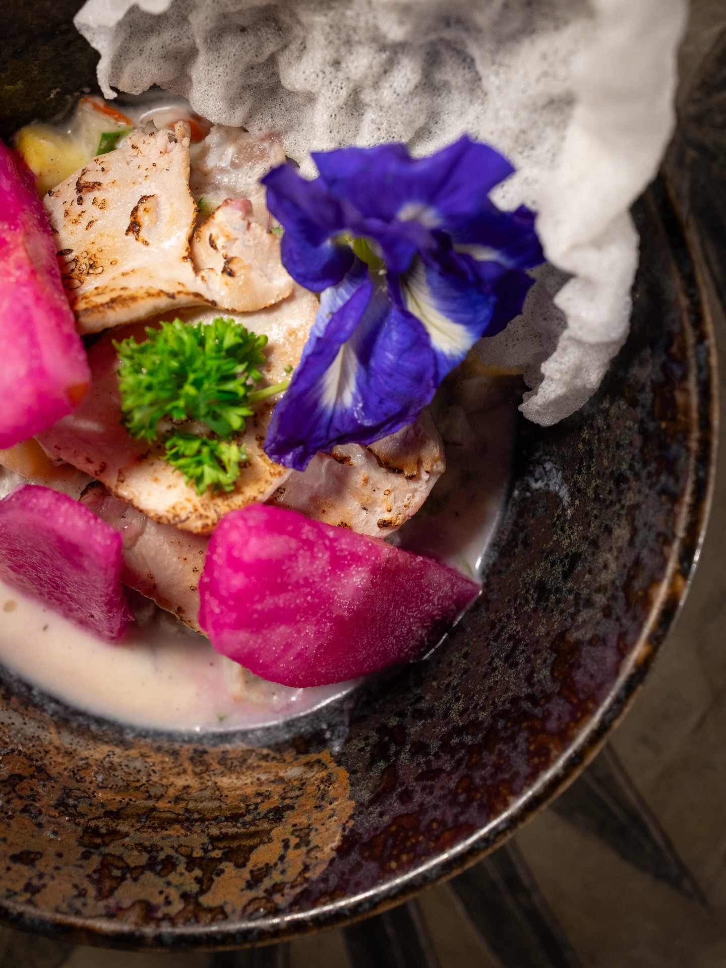 Seafood ceviche with edible flowers and butterfly pea