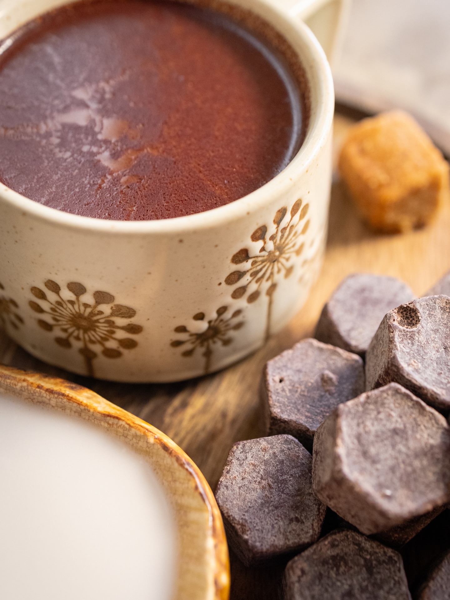 Rich dark hot cacao in a ceramic cup with cacao tablets