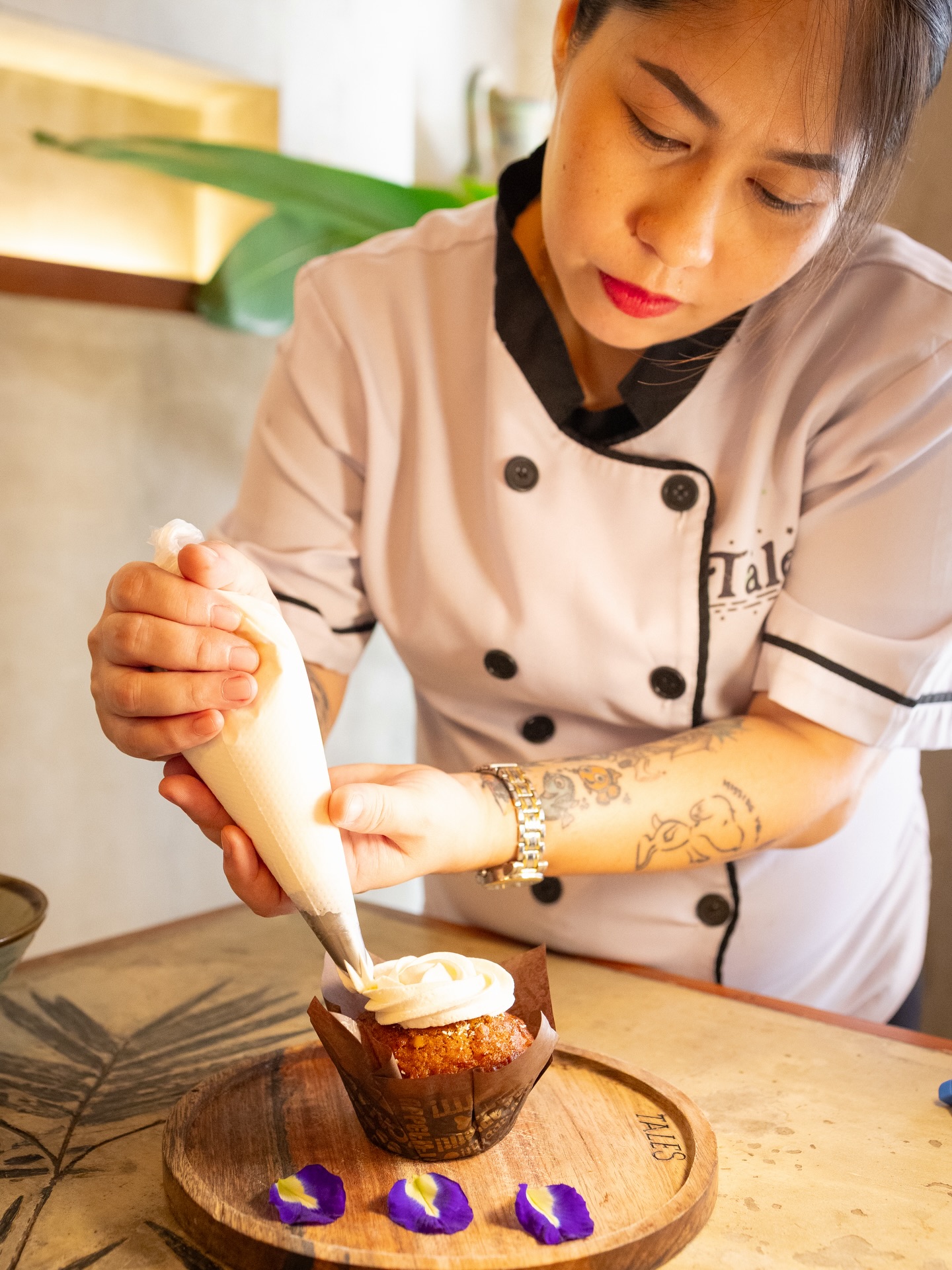 Chef piping cream onto a cupcake at Tales of the Islands